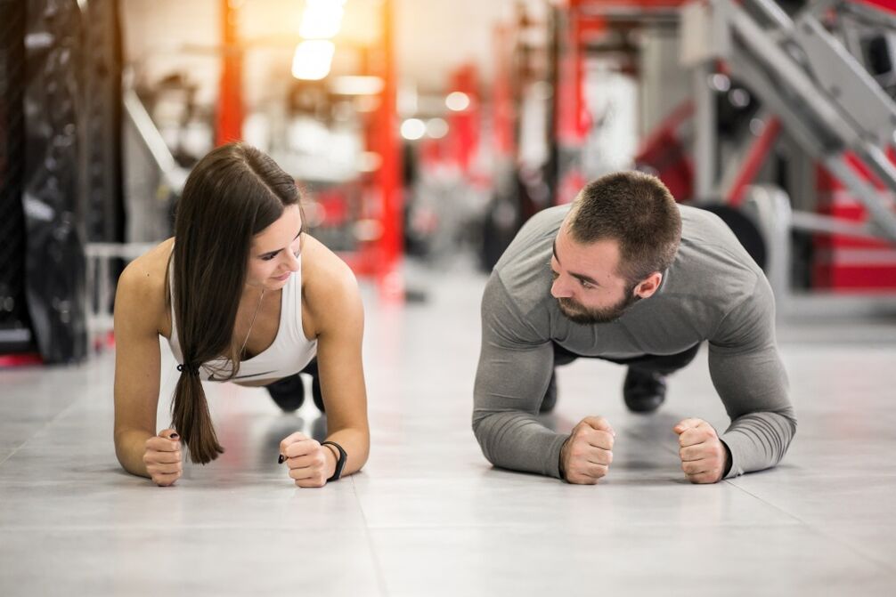 Ein Mann und eine Frau machen die Plank-Übung, die für alle Muskelgruppen konzipiert ist